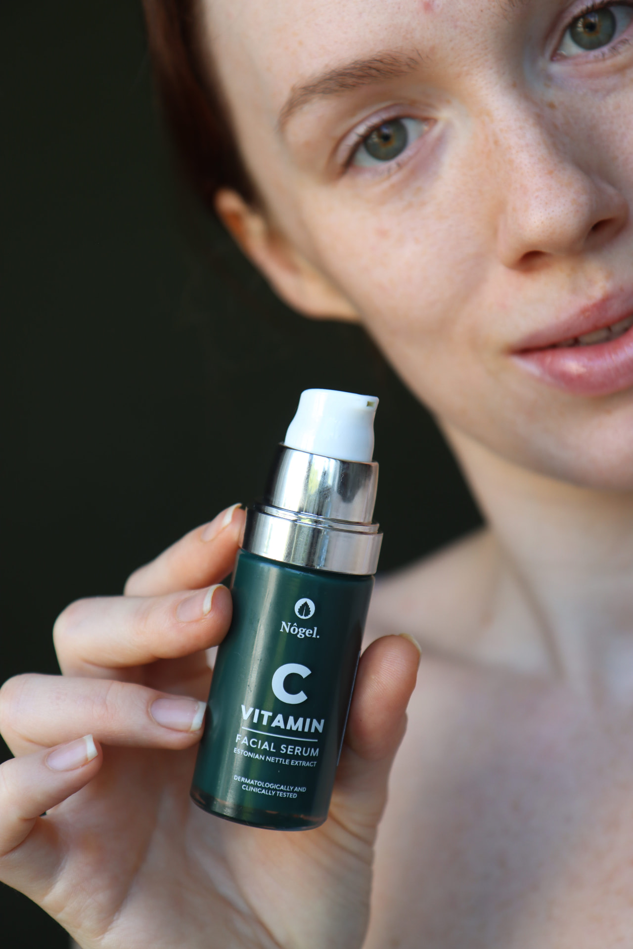 Nogel Organics vitamin C facial serum held in front of the face