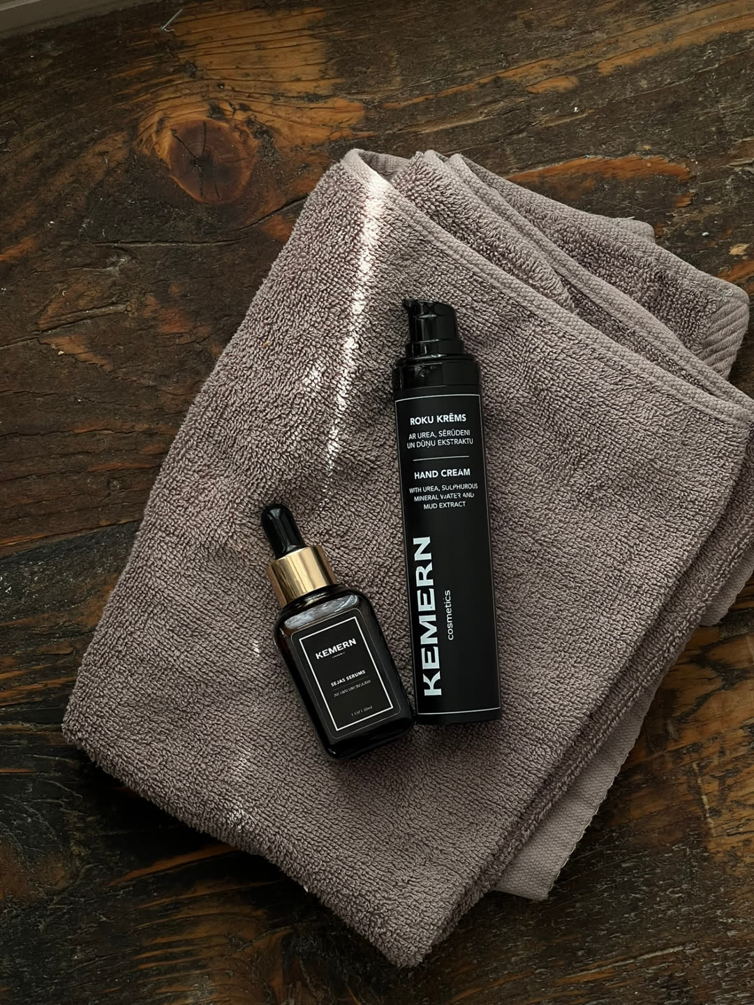 Kemern hyaluronic acid face serum and mud hand cream on a folded towel